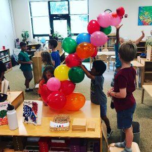 Children making a bridge out of balloons, a STEAM activity.